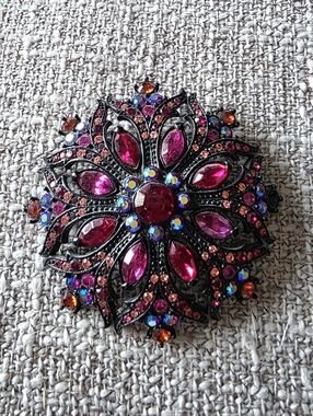 Joan Rivers brooch featuring wine red, pink, & iridescent rhinestones.